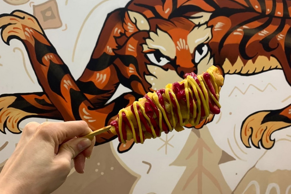 Корн-дог подают на деревянных палочках-шпажках и поливают соусами.