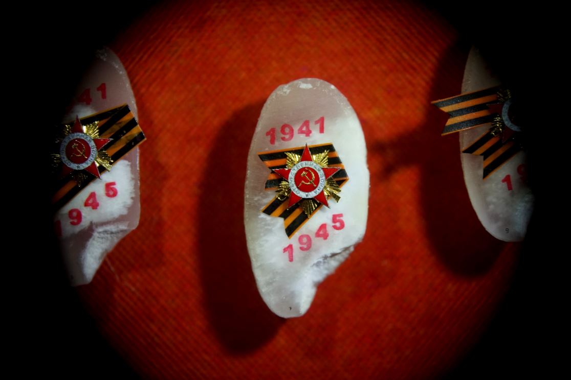 Орден Отечественной войны 1-й степени. Высота — 2 мм. Материалы: золото, олово и масляная краска.