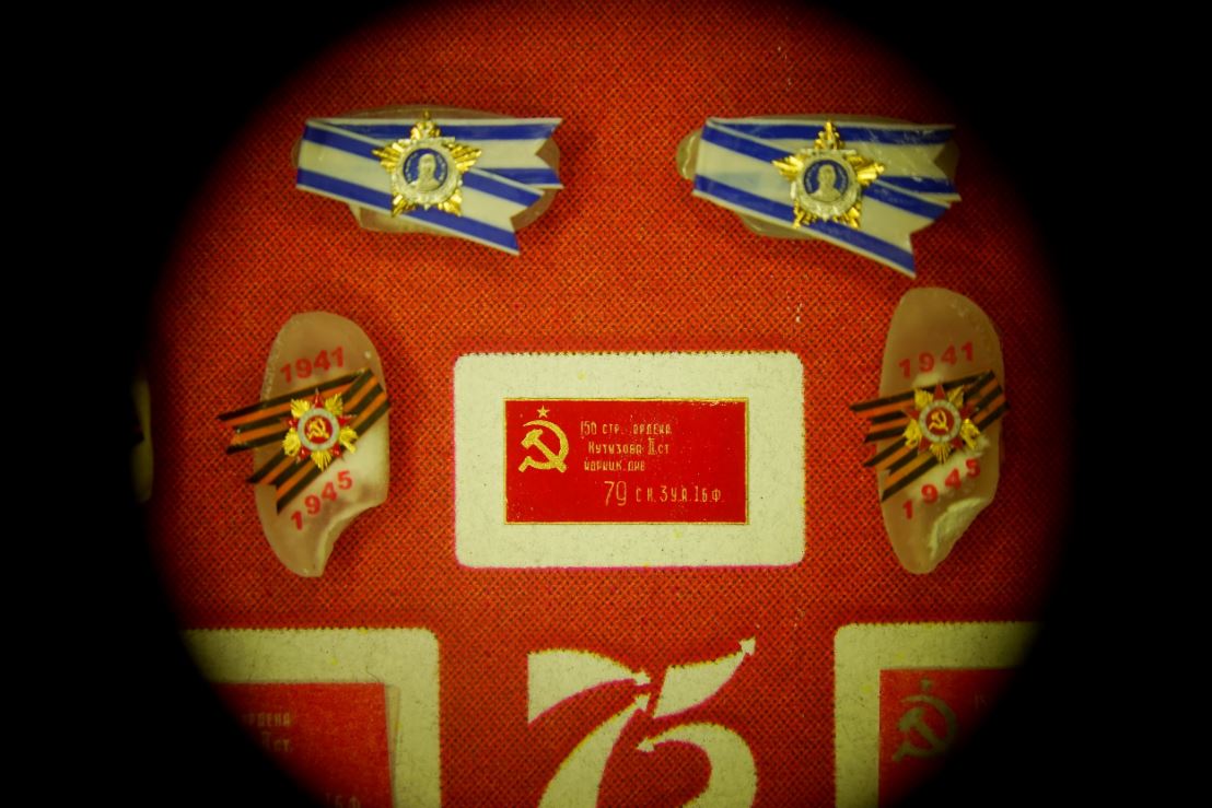 Копия Знамени Победы на золотой пластинке. Размер: около 6×3 мм. Материалы: золото и масляная краска. Её Левша сделал за один день, но ещё два дня ушло на то, чтобы высохла краска.