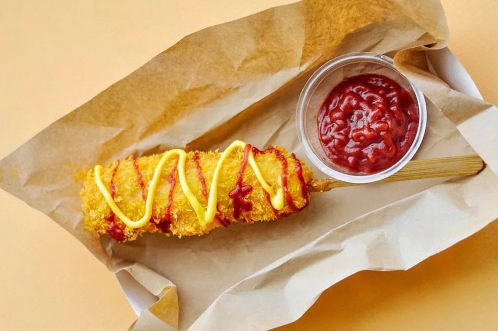 По сути, это корейский аналог хот-дога, только вместо булки — хрустящий кукурузный кляр. Оболочку для сосиски можно выбрать разную — обернуть её кубиками картофеля фри или обжаренной лапшой. Главное — чтобы всё звонко хрустело!