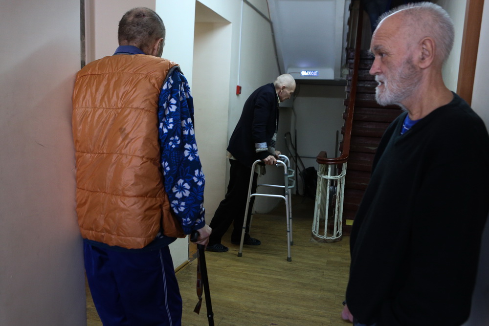 В назначенный час в столовую стягивается народ: кто-то приезжает на коляске, другие передвигаются при помощи ходунков, третьи, держась за поручни на лестнице, добираются сами. Лежачим относят еду соседи по комнате.