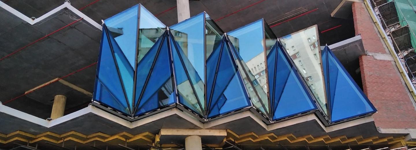 Ребристый зеркальный фасад начали монтировать у ТЦ «Грани» на Маркса