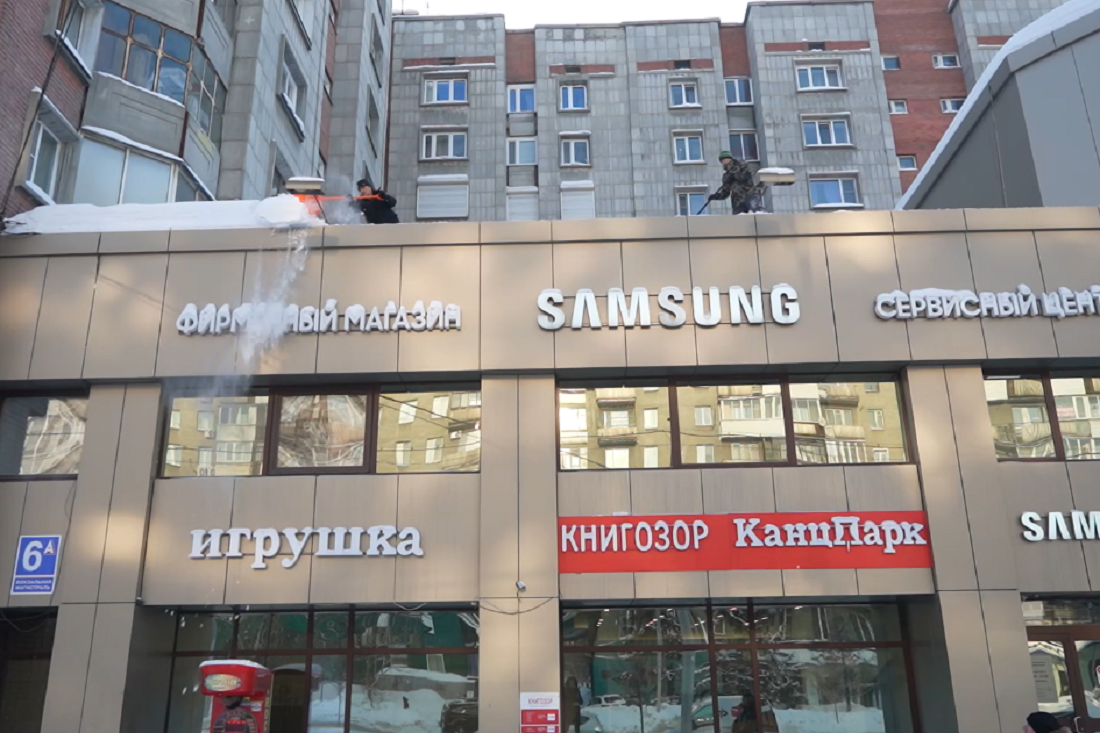 Со зданий в центре Новосибирска сбрасывают снег: треть крыш уже очистили