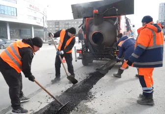 Рециклер кладёт заплатки из горячего асфальта на улице Кошурникова