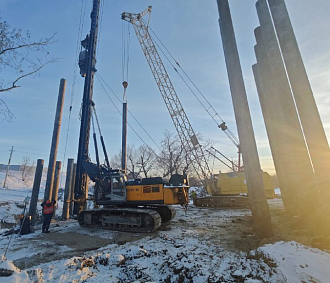 Мощным гидромолотом забили сваи для временного моста на Петухова