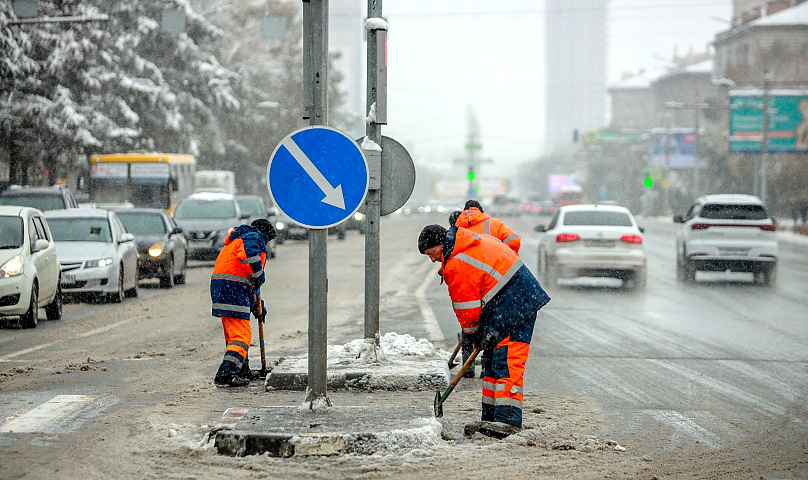 Перед похолоданием ДЭУ убирают с улиц Новосибирска снег с талой водой
