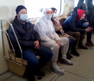 Напуганный коронавирусом человек в защитном костюме разъезжает в метро